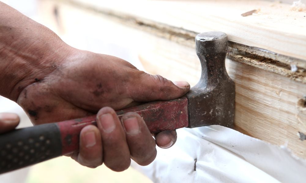 close up photo of a hammer on a piece of wood