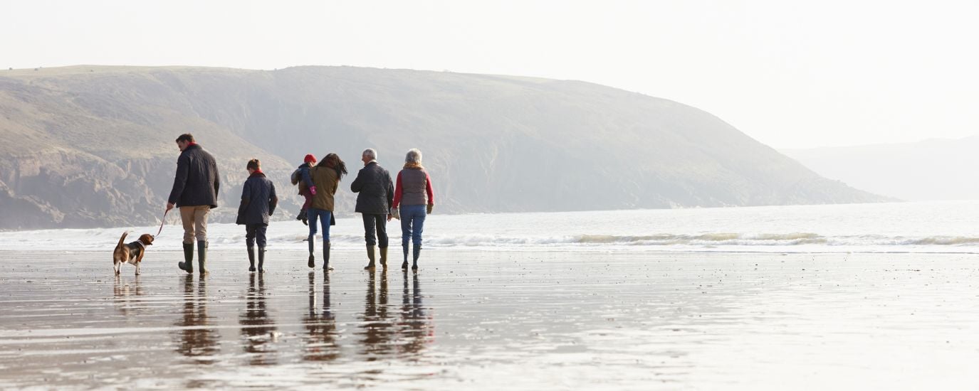 family walking on beach in cornwall